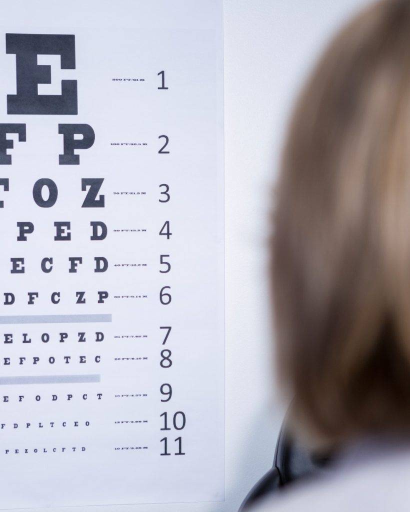 optometrist looking at-eye chart